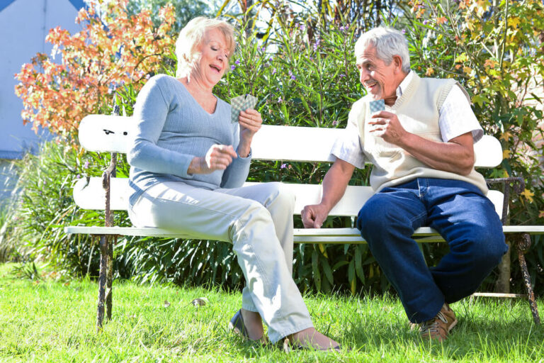 Everlan of Hixson | Two seniors playing cards on a bench outside