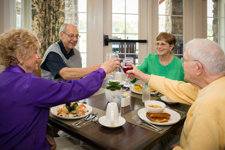 Everlan of Johnson City | Residents doing a cheers while having dinner in the dining room